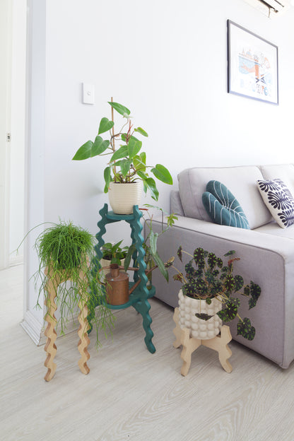 Three Xigglie Plant Stands. Australian designed and made in Birch Plywood and moisture-resistant MDF. Supporting plants in a modern living room.
