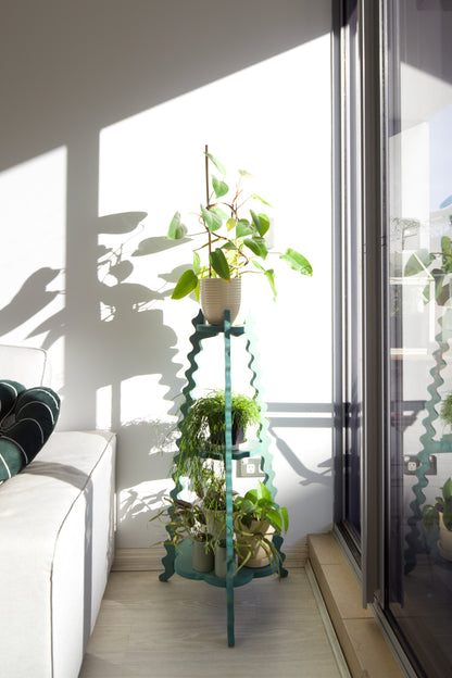 A Xigglie Sage Threezy Plant Stand.  Australian designed and made in green moisture resistant MDF. Supporting indoor plants in modern living room.