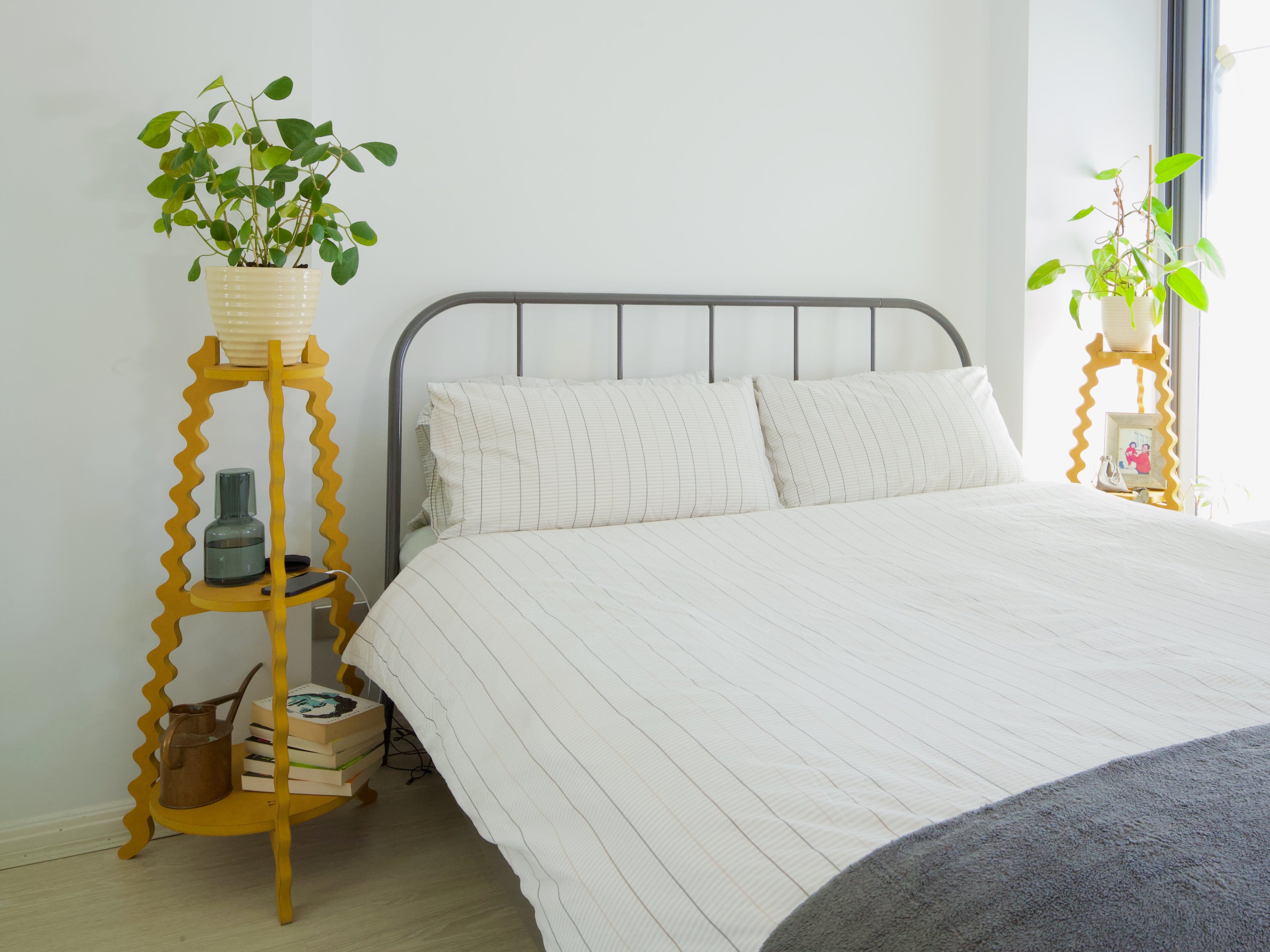 Two Xigglie Saffron Threezy Plant Stands. Australian designed and made in yellow moisture resistant MDF. Supporting plants, books etc in modern bedroom.