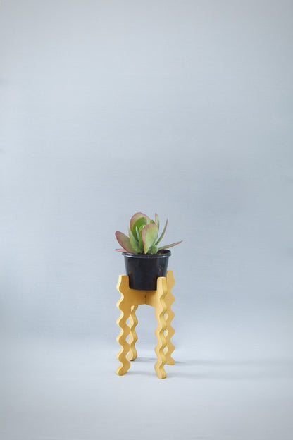 A Xigglie Saffron Middie Skinny Plant Stand. Australian designed and made in yellow moisture-resistant MDF, supporting a plant & pot.